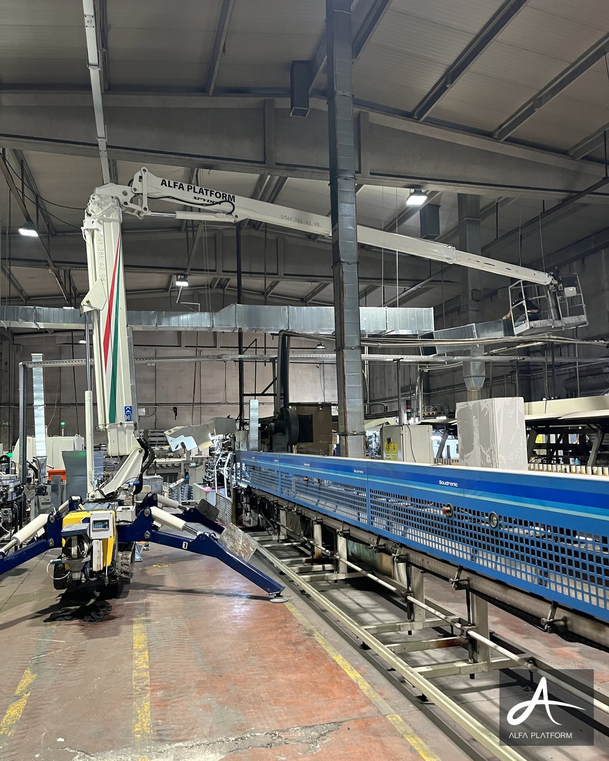 Bir fabrika içinde çalışan örümcek platform, sepeti yukarıda.
