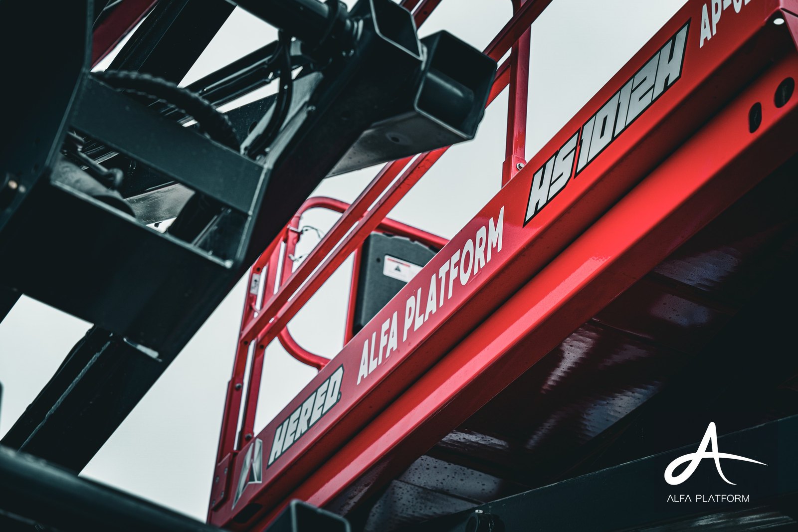 Kırmızı bir makaslı platformun detaylı yakın çekimi, dış mekanda.