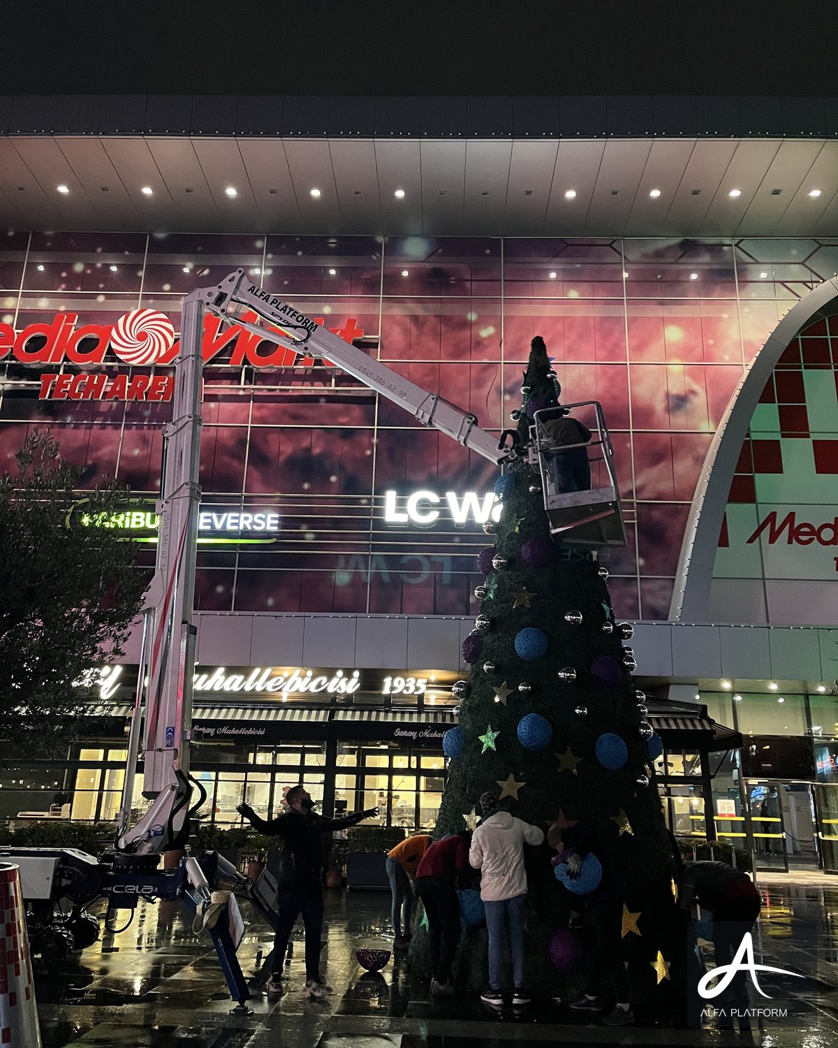 Eklemli platform ile dış cephede Noel ağacı süsleme çalışması yapılıyor.