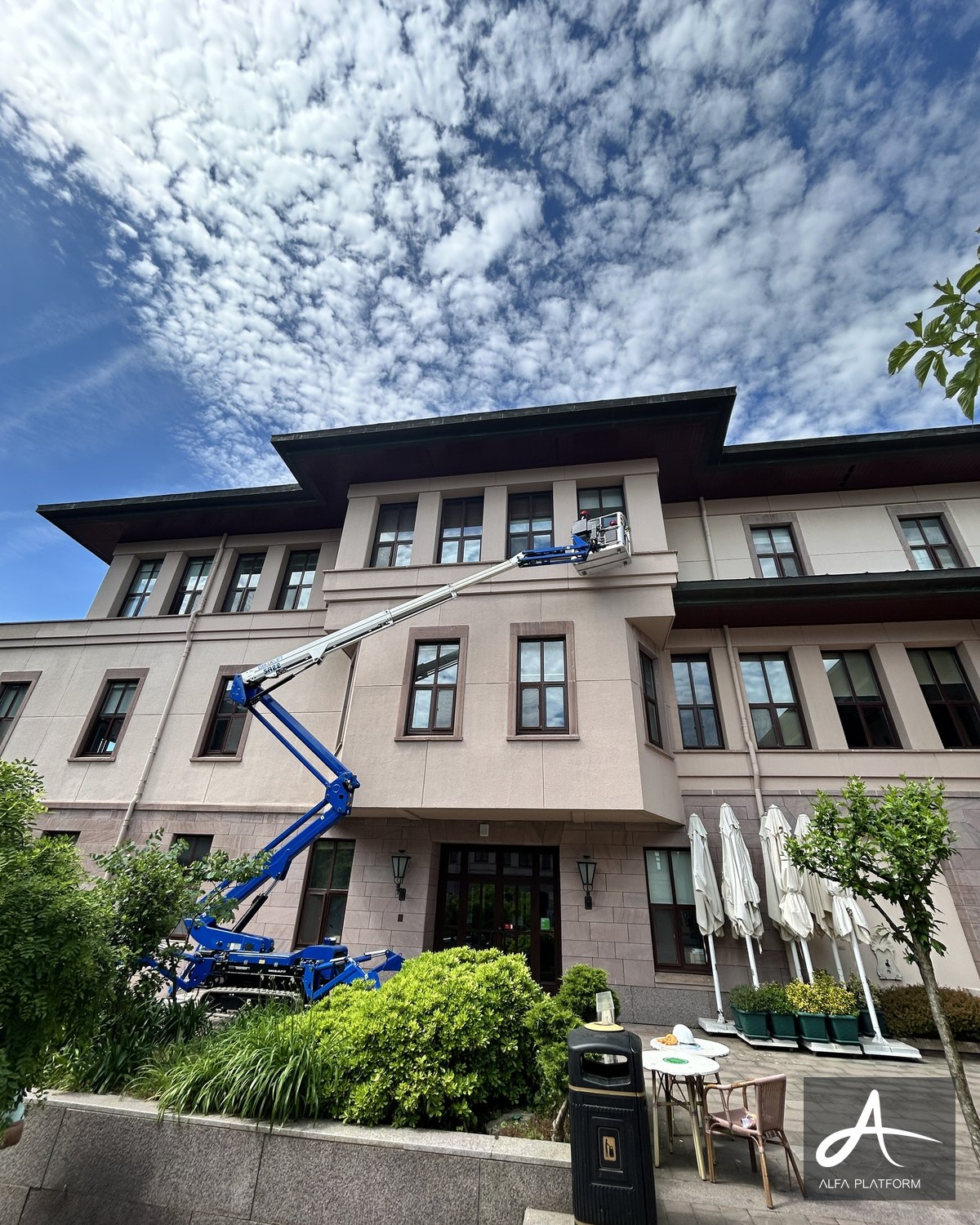 Mavi eklemli platform bir binanın penceresine doğru uzanmış.